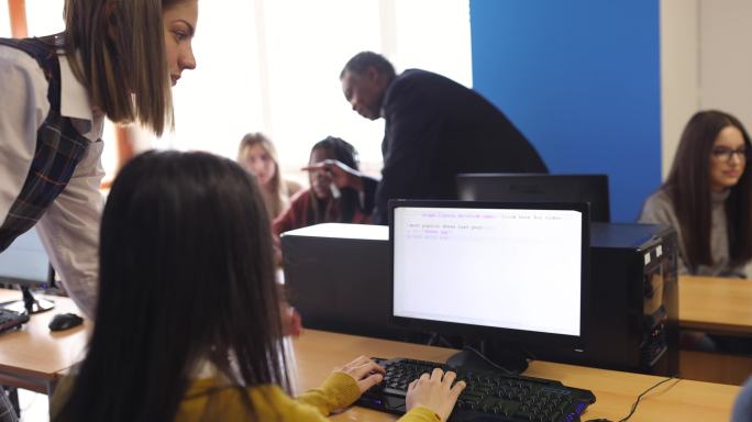 在高中计算机实验室帮助学生使用计算机的老师
