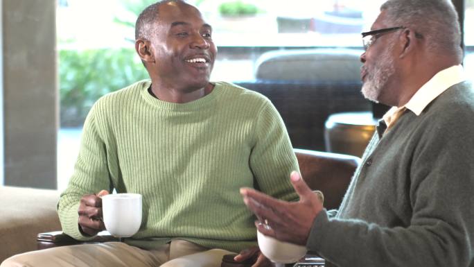 两个非裔美国人一边喝咖啡一边聊天