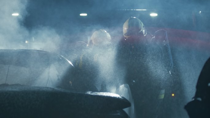 斯洛莫消防队员在夜间发生事故后用水将烧毁的汽车淋得湿透