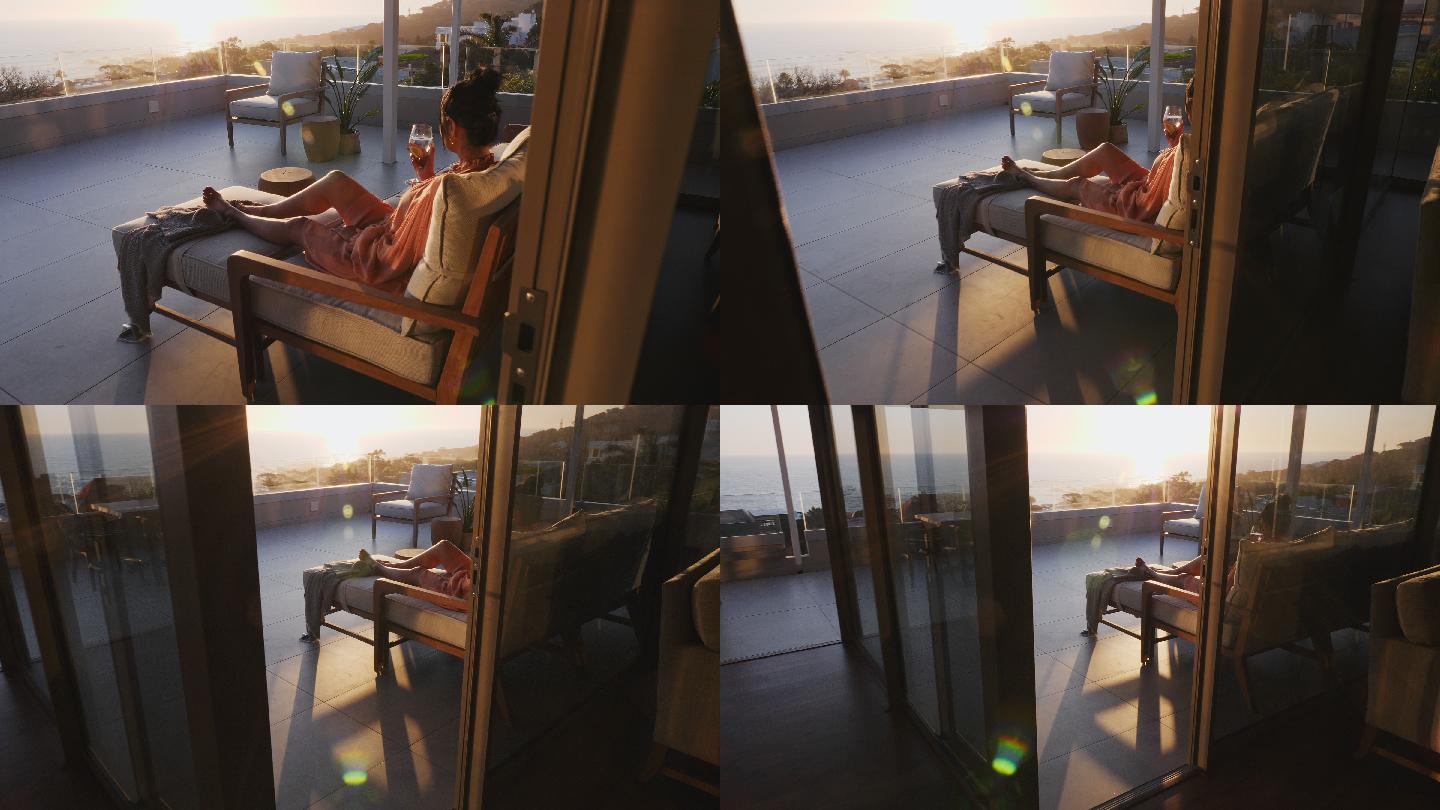 在阳光明媚的豪华露台上休息的女性，可以欣赏日落海景