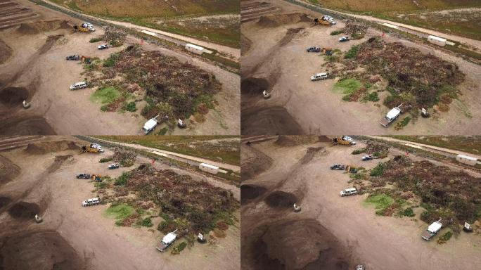 空中无人机视角下的有机覆盖堆肥设施，有成堆的树枝和有机材料用于回收