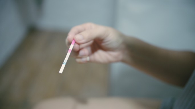 持有阳性妊娠检测试剂盒的女性