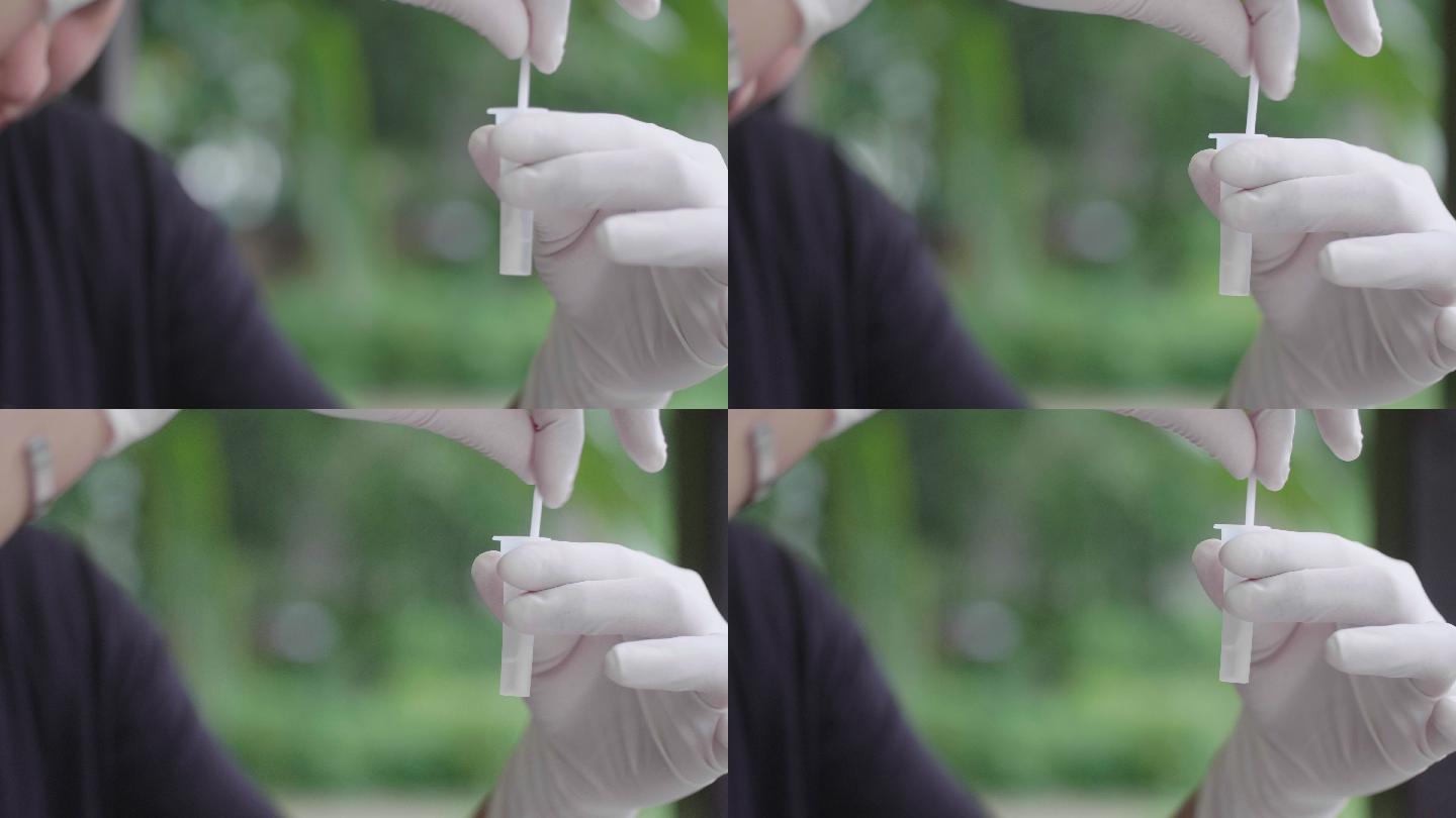 亚洲女性用棉签保存样本以检测新冠肺炎。