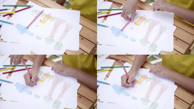 儿童用彩色铅笔在纸上画卡通的场景，教育背景
