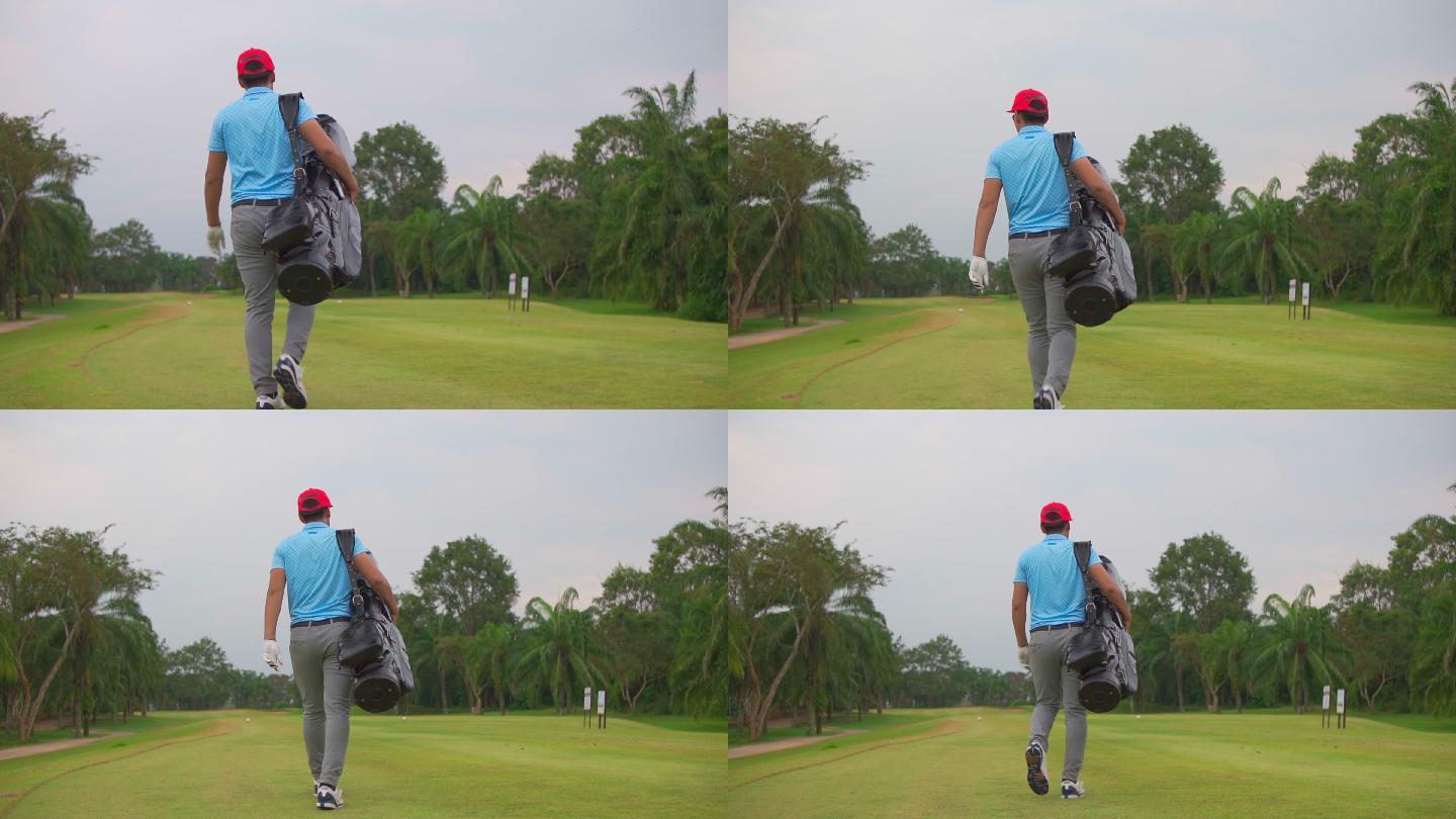 一名亚洲男子高尔夫球手在高尔夫俱乐部散步并携带高尔夫球袋