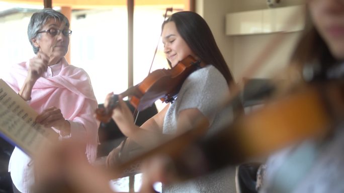 小提琴老师教一个高中女生拉小提琴