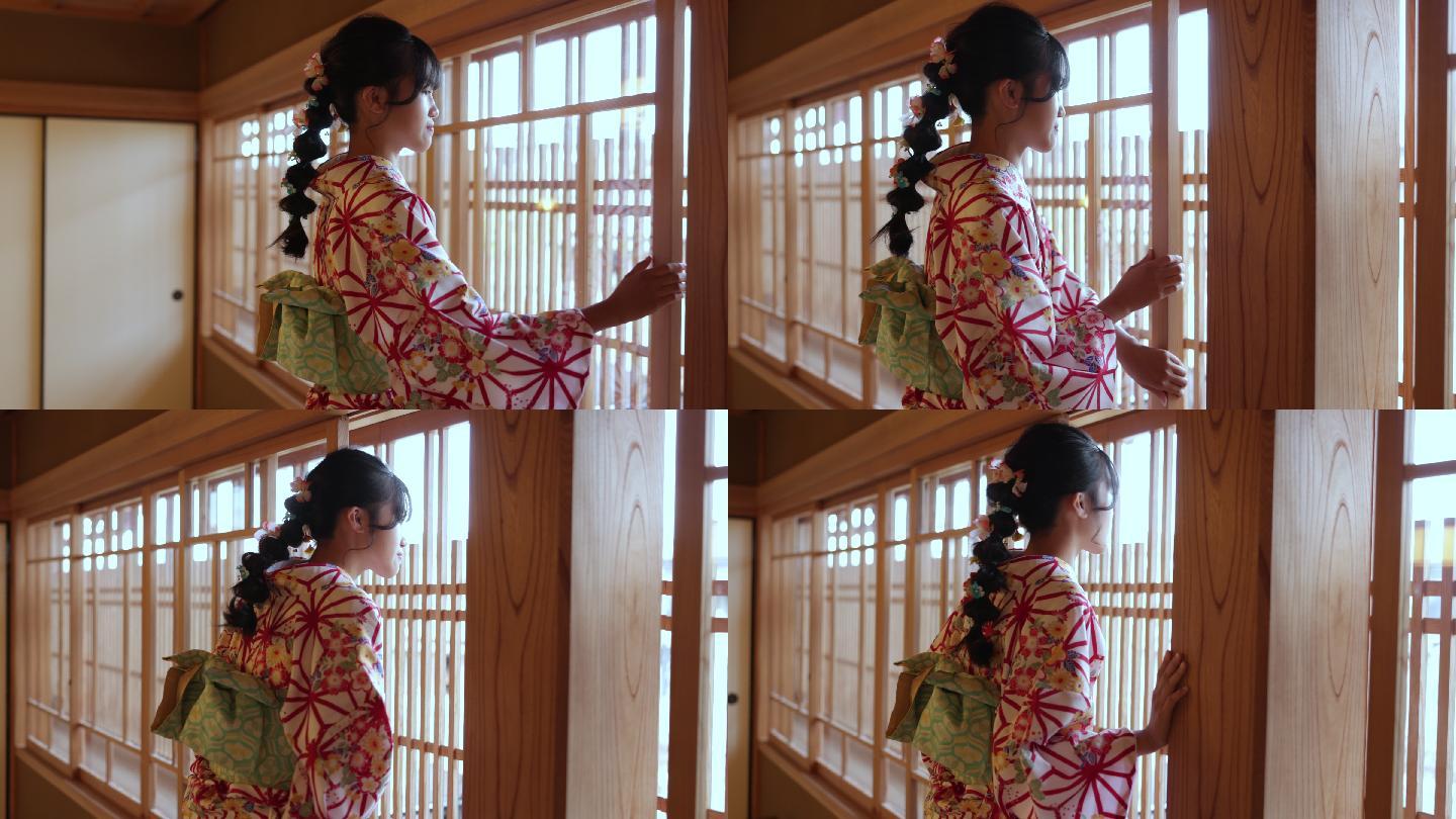 穿着和服的少女从日本榻榻米房间透过窗户看