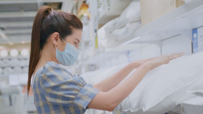 在家居装饰店选购枕头的迷人女性。