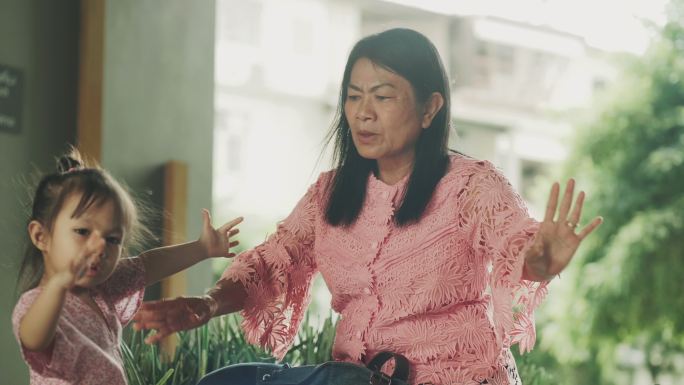 亚洲祖母在积极地教她的孙女飞行和模仿鸟