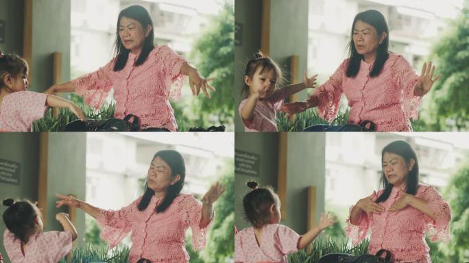 亚洲祖母在积极地教她的孙女飞行和模仿鸟