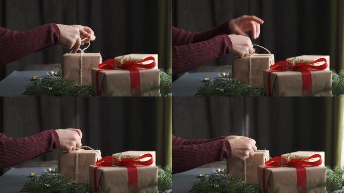 准备圣诞礼物的女人。圣诞背景、礼品盒和松枝
