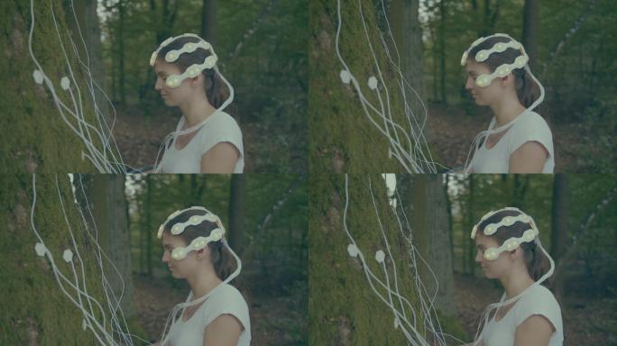 森林浴疗法。那个女人用脑扫描仪连接到老树上。面部特写