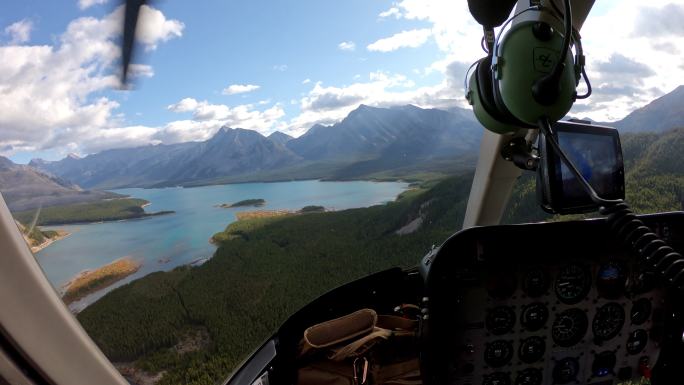 在洛基山脉绿松石湖的秋天森林里，飞行员驾驶直升机