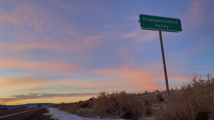科罗拉多州一个真实路标的黄昏时分，路标上写着失望谷，象征着一个极度绝望和沮丧的地方