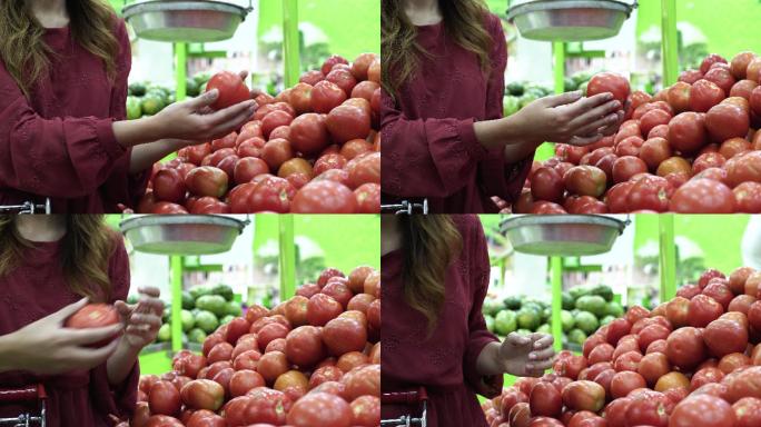 一位在杂货店里的拉丁女人根据自己的喜好挑选西红柿，然后把它们放进购物车
