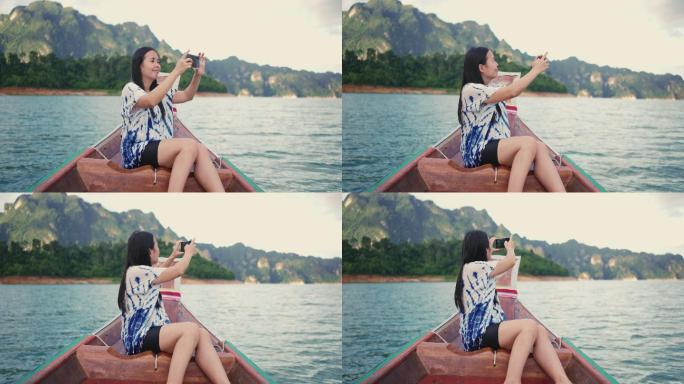 在泰国高索国家公园乘船旅行时，一名亚洲女性用智能手机拍照