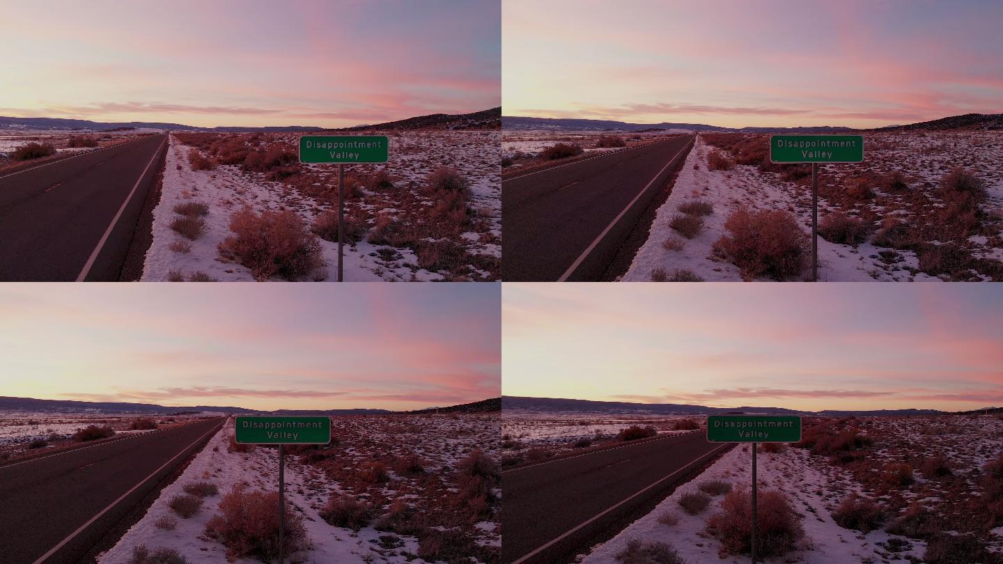 无人驾驶飞机拍摄了科罗拉多州一个真实的路标，上面写着失望谷，一个充满绝望和沮丧的地方，美丽的日落