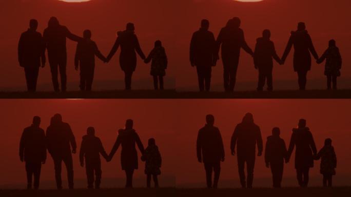 斯洛·莫尔斯（SLO MO LS）一家的剪影是在日落时分在山上散步