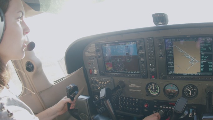 年轻成年女飞行员设置起飞动力并与控制塔通信