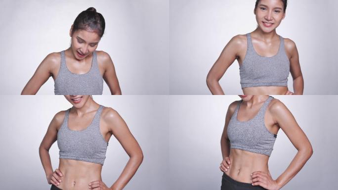 白色背景的年轻亚洲女性看着自己的腹部和腰部进行锻炼和控制饮食。