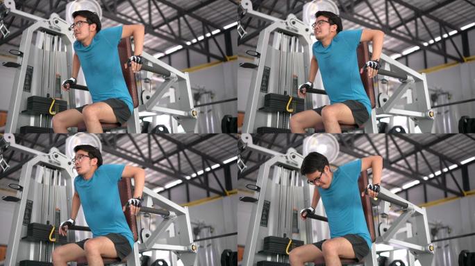 亚洲男子在健身房使用训练机锻炼手臂三头肌