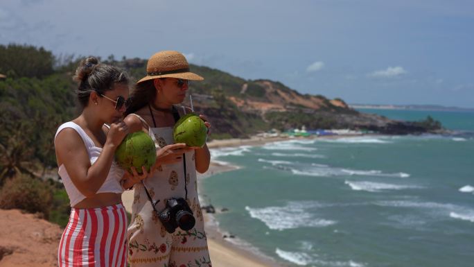 在海滩上喝椰子水的游客