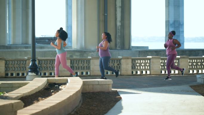三名多种族女性在城市滨水区跑步