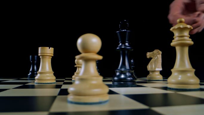 DS国际象棋游戏中白人男性的手向黑人国王倾斜