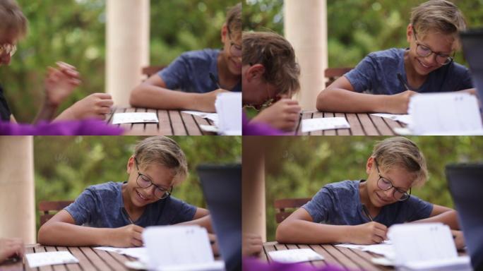 青少年坐在后院的桌子旁写明信片