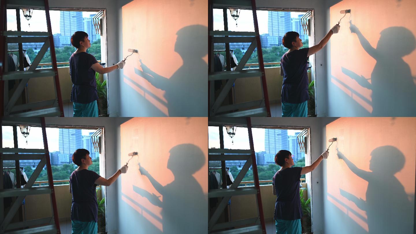 一位亚裔中国中年女性在夕阳下粉刷起居室，公寓翻修