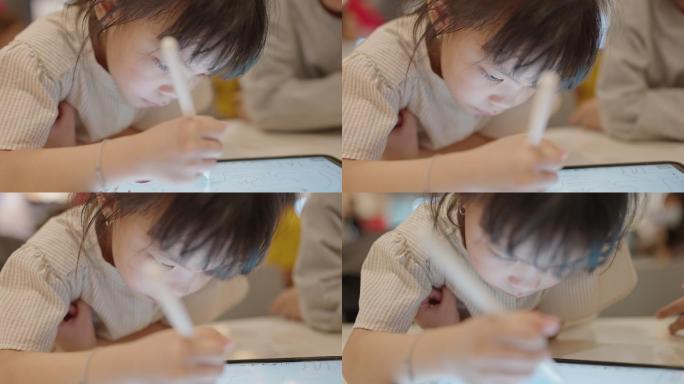 亚洲小女孩在数码平板电脑上使用数码铅笔画画，亚洲家庭生活方式与科技设备概念