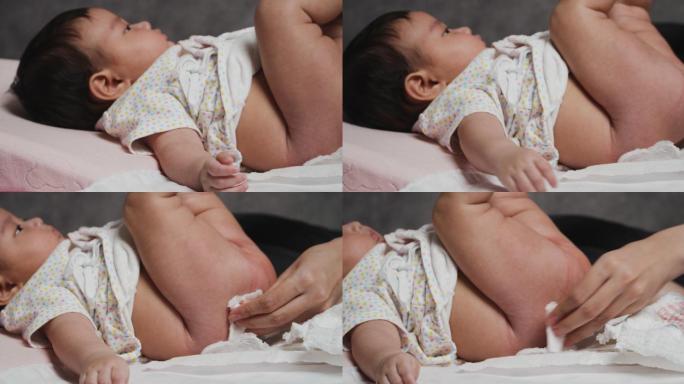 亚洲母亲在家里为4个月大的女婴亲手换尿布。
