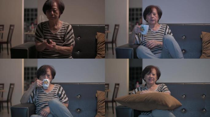 亚裔中国老年女性在周末闲暇时间独自在家看电视