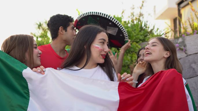 一名十几岁的拉丁女孩与朋友在户外庆祝墨西哥足球队获胜的照片