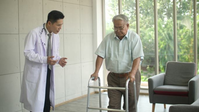医生用助行器支撑他的老年患者