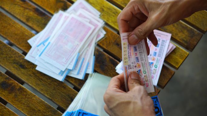 亚洲男子将政府彩票放入塑料信封中