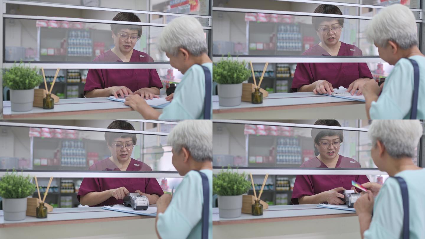 亚裔华裔老年女性用信用卡支付医疗费用NFT诊所女护士手持信用卡读卡器