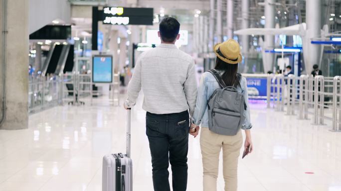 带着医用口罩的情侣旅行者在机场度假