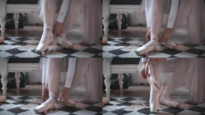 美丽的年轻芭蕾舞演员在演播室的地板上系鞋，鞋上系着丝带