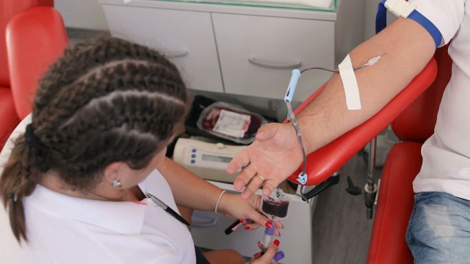 护士抽取血样进行分析。善行。为你的身体献血的好处。接受输血者的手。临床献血者的特写镜头