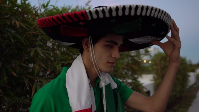 一个十几岁的拉丁男孩在户外戴着一顶罩衫的肖像