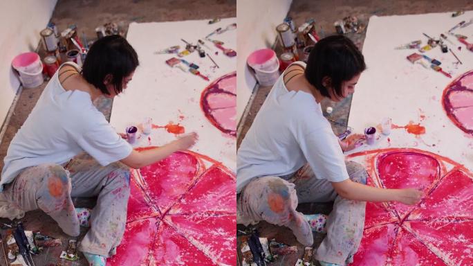 富有创意的女画家用玫瑰色颜料在画布上绘画