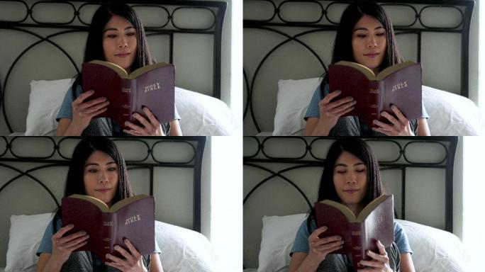 微笑的东亚妇女在家读圣经