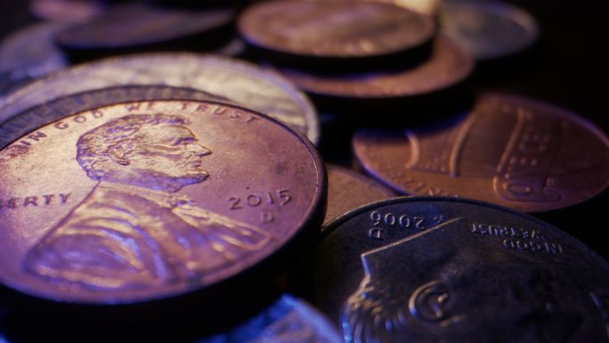 木桌上堆积的美元硬币的特写宏观移动滑块镜头
