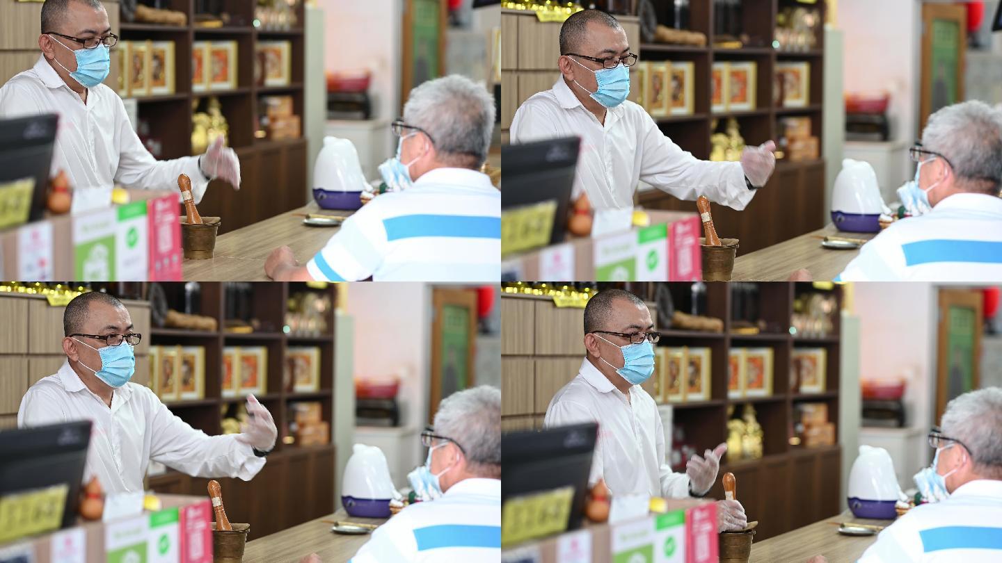 在中草药店为老年患者提供讲解建议的亚裔华人替代保健工作者