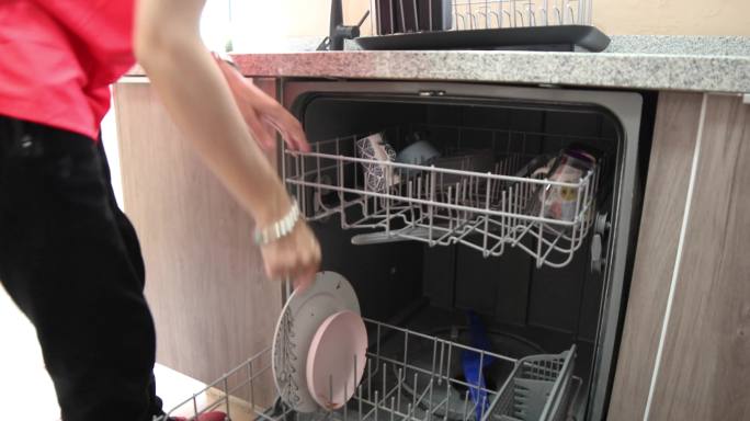 女人把盘子放在洗碗机里