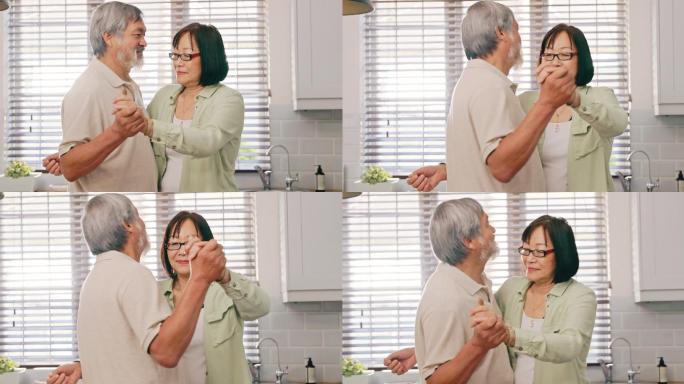 一对亚洲老夫妇在家的厨房里跳舞。幸福的老年夫妇在家里的厨房里结伴跳舞