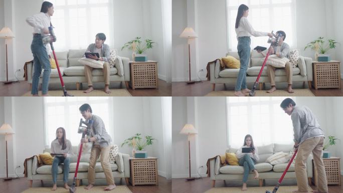 一对亚洲夫妇用吸尘器清洁起居室，这是一种人性化和家务化的概念