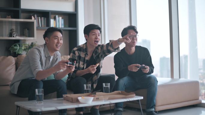 亚裔中国年轻人喜欢周末在客厅和朋友玩电子游戏