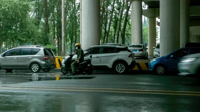 雨中大桥下避雨的汽车和骑车人